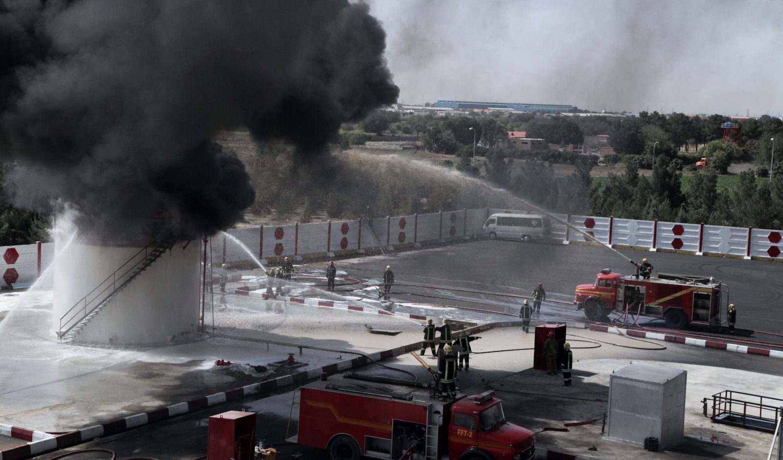 Fire crews suppressing an industrial tank fire during a HazMat exercise